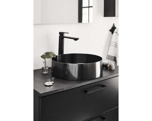 Modernt badrum med svart tvättställsskål och blandare på ett tvättställsskåp