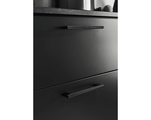 Svarta lådfronter med räfflade handtag i en köksmiljö.