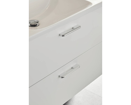 Detaljvy av ett vitt tvättställsskåp med två lådor och rektangulära handtag