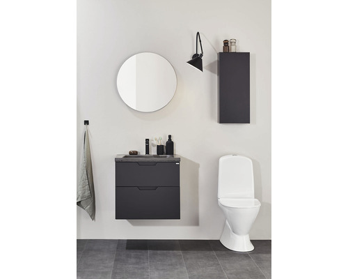 Modernt badrum med tvättställsskåp, spegelskåp, vägglampa och toalett.