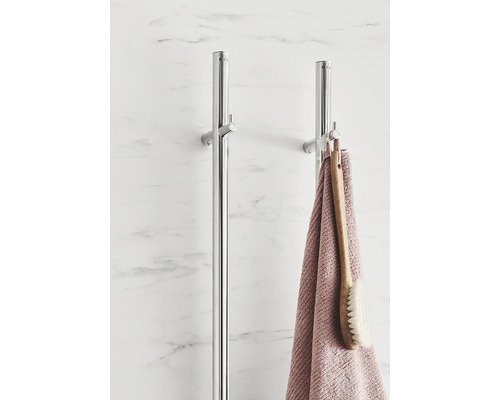 Två handdukshängare i metall med handduk och borste