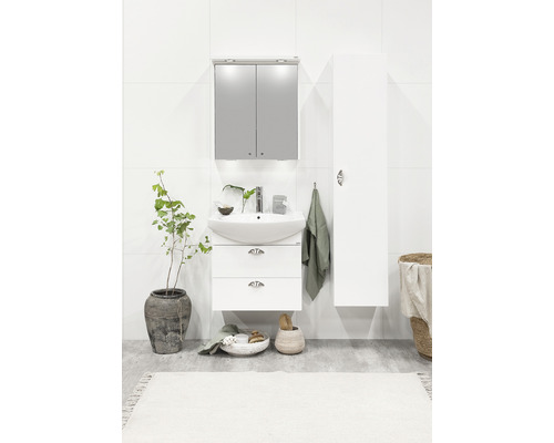 Ljust badrum med handfat, spegelskåp, handduk och dekoration