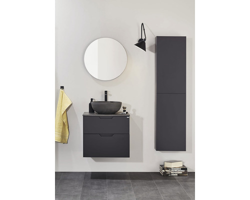 Badrum med tvättställsskåp, rund spegel, vägghängd skåp och vägglampa