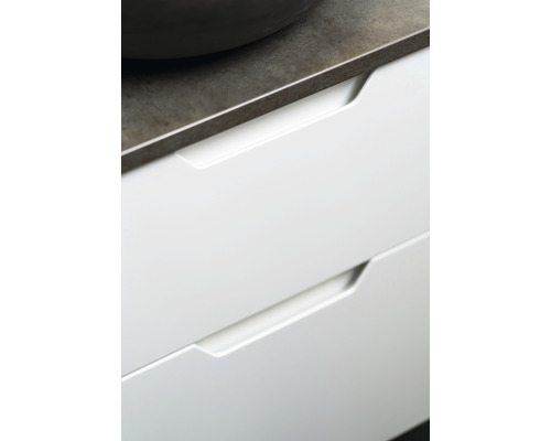 Detalj av vita lådor med infällda handtag under en bänkskiva