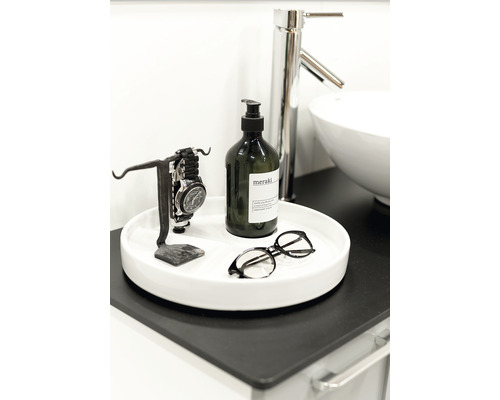 Dekorativt badrumsarrangemang med tvålpump, klocka, glasögon och handfat