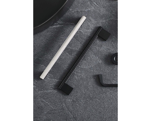 Två möbelhandtag på en mörk yta.