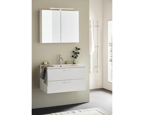 Modernt badrum med vitt tvättställsskåp, spegelskåp och handdukshängare