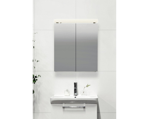 Spegelskåp med belysning ovanför ett handfat i ett badrum