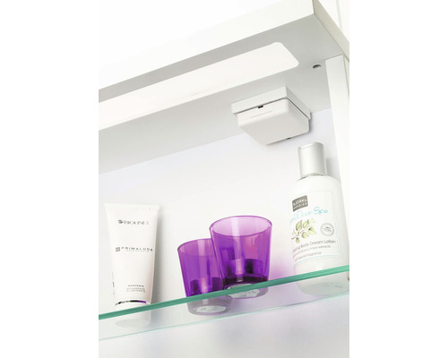 Badrumsscen med kosmetika och dekorativa föremål på en glashylla