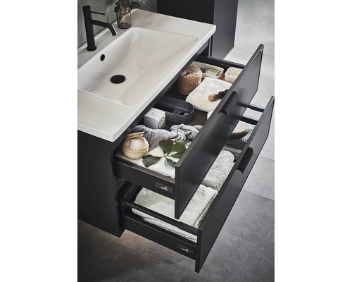 Öppet badrumsskåp med handfat och lådor för förvaring av handdukar och badrumsartiklar.