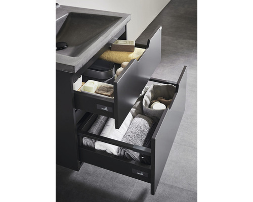 Tvättställsskåp med öppna lådor och handdukar