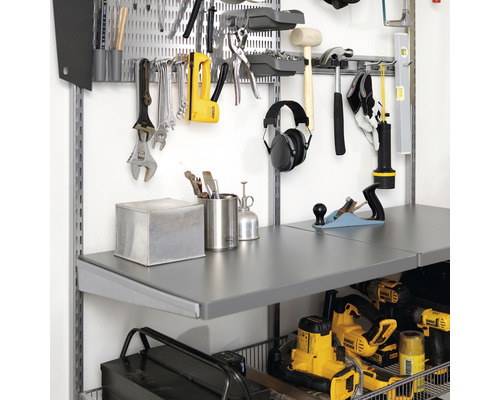 Arbetsbänk med verktyg och tillbehör på en verktygspanel.