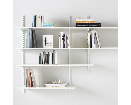 Hyllsystem med flera hyllor och böcker mot en vägg
