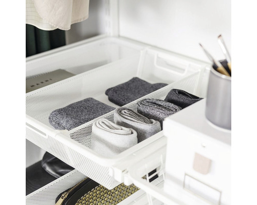 Utdragbar trådhylla med strumpor och kläder i garderoben