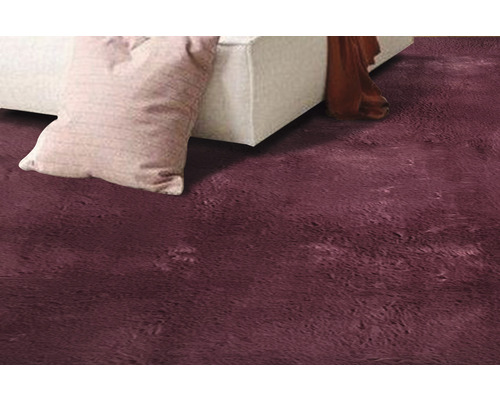 Närbild av en ryamatta med kudde och soffa