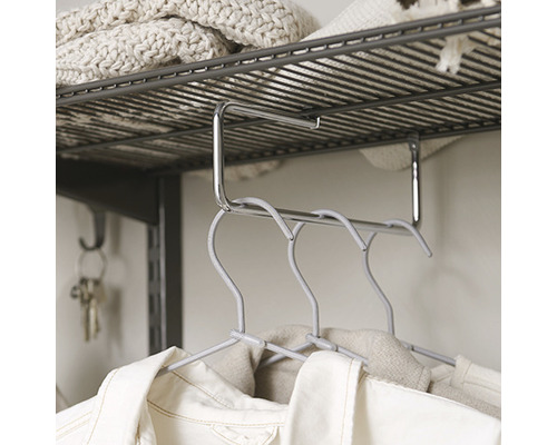 Klädstångorganisatör under en hylla med hängande kläder.