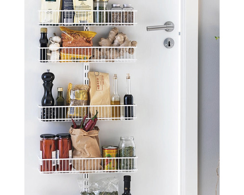 Vitt hyllsystem monterat på dörren med livsmedel.