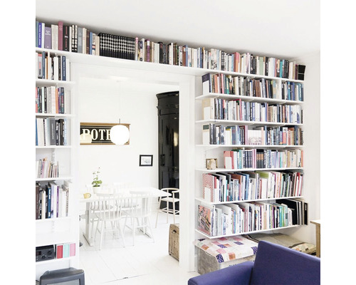 Ljust vardagsrum med bokhyllor, matbord och stolar