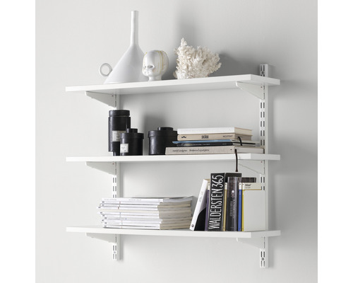 Hyllsystem med tre vita hyllplan och diverse dekorativa föremål som vaser, böcker och tidskrifter
