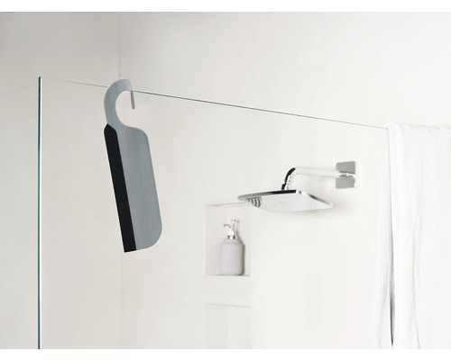 Duschskrapa med hållare hänger på duschväggen