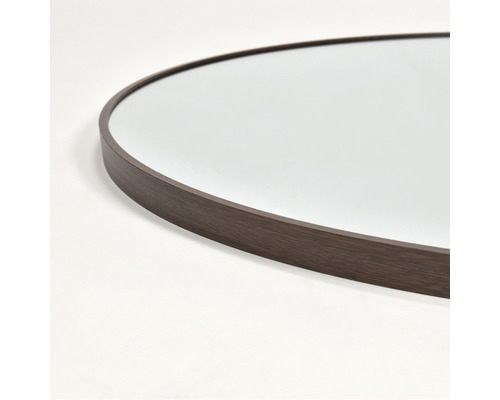 Detaljbild av en rund spegel med träram