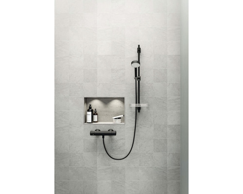 Badrumsvägg med inbyggd hylla, duschhuvud och armatur