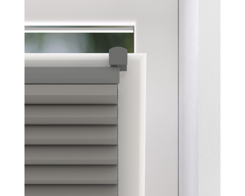 Detaljvy av en grå plisségardin på ett fönster