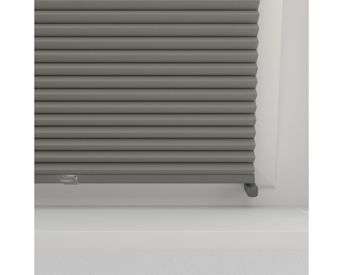 Närbild av en grå plisségardin för fönster, för ljusreglering och dekoration