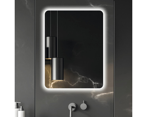 Belyst spegel i badrum med armatur och hängande lampa