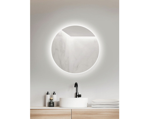 Badrum med rund spegel, tvättställ och armatur