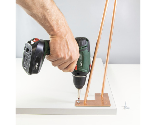 Sladdlös skruvdragare fäster bordsben på en bordsskiva