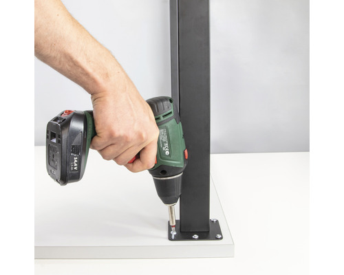 Sladdlös skruvdragare vid montering av en svart metallstolpe