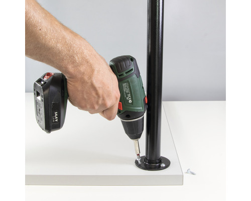 En person fäster en metallstång på en platta med en sladdlös skruvdragare.