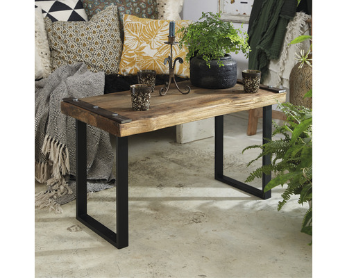 Dekorativt vardagsrum med soffa, kuddar, sidobord i trä med metallben och växter