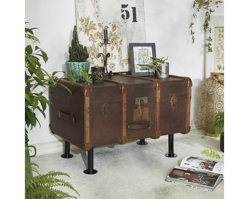 Dekorativt vardagsrum med en byrå i resväskeformat på ben och heminredningsdetaljer