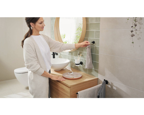 "Ljust badrum med tvättställ, spegel, handdukshängare och toalett