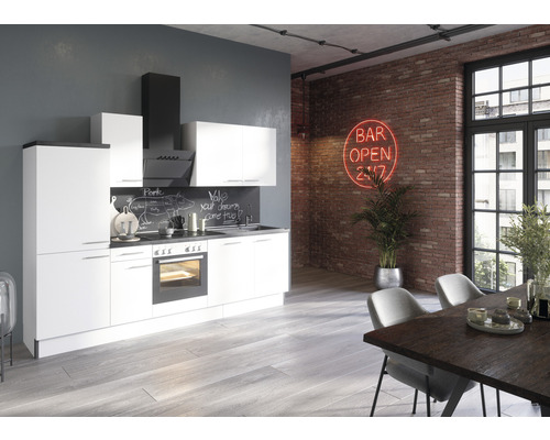 Modernt kök med vita skåp, köksfläkt och matbord i ett rum med tegelvägg