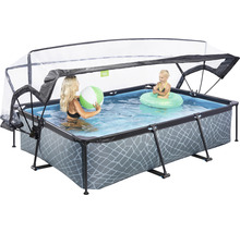 Rektangulär pool med tak, fylld med vatten, där en kvinna med en boll och ett barn med en badring leker