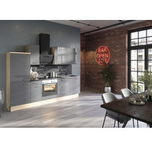 Modernt kök med grå skåp, spishäll och fläkt i ett ljust rum.