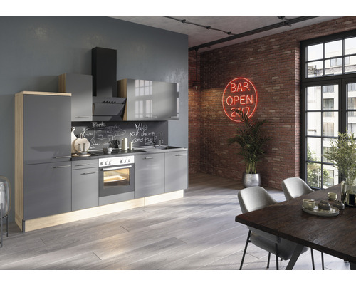 Modernt kök med grå skåp, spishäll och fläkt i ett ljust rum.