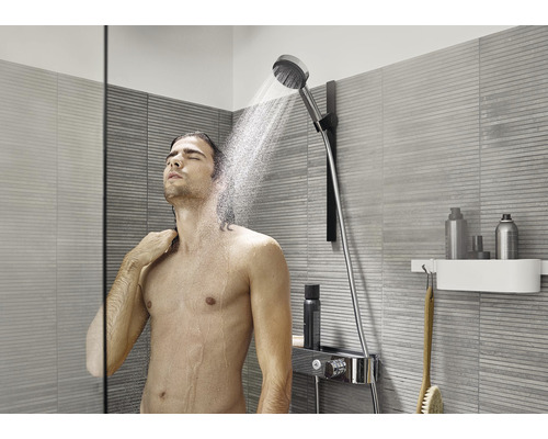 Man under en handdusch i ett modernt badrum