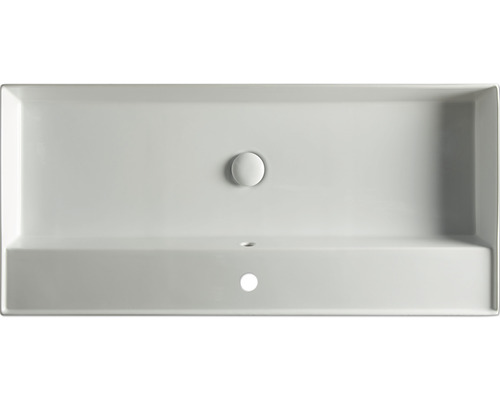 Ovanifrån av en rektangulär tvättställ av keramik med avloppsplugg och kranhål