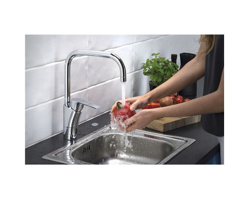 Kvinna tvättar paprika under en köksblandare