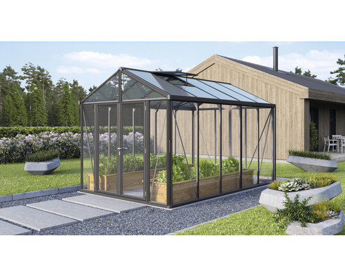 Växthus med växter i trädgården