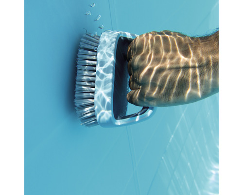 En person rengör en pool med en borste under vattnet.