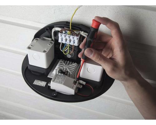 Installation av en utomhuslampa med en skruvmejsel på elektriska komponenter