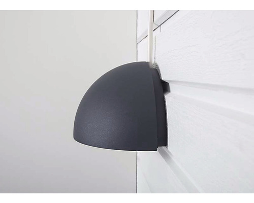 Halvrund utomhusvägglampa på vit vägg