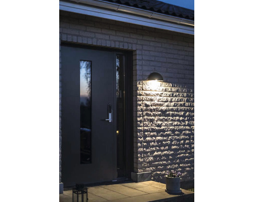 Belyst entré med ytterdörr och utomhusbelysning på en stenvägg