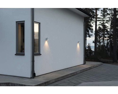 Husvägg med två fönster och två utomhuslampor