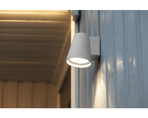 Konformad vägglampa för utomhusbruk på en husvägg